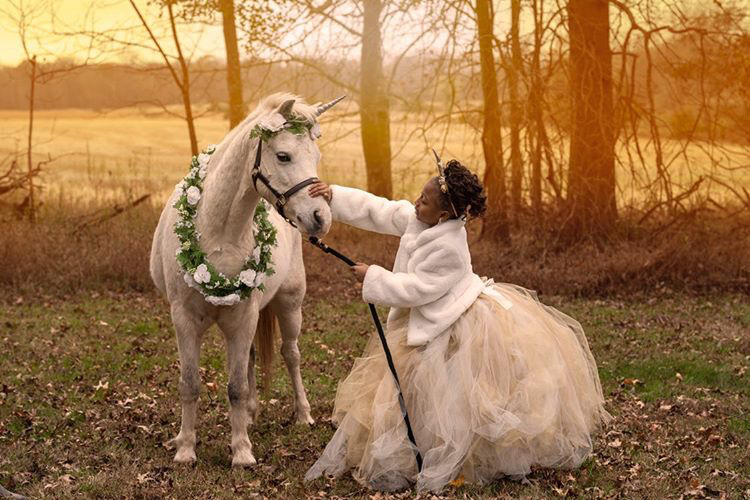 Unicorn photoshoot of girl touching horse